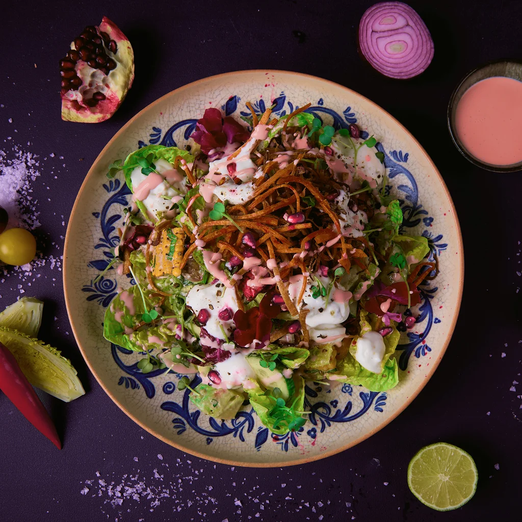 Frischer Salat mit Romanasalat, Radicchio, Avocado, Gurke, Kirschtomaten, Mais, roten Zwiebeln, Koriander, Minze, Chili und Himbeer-Distel-Dressing